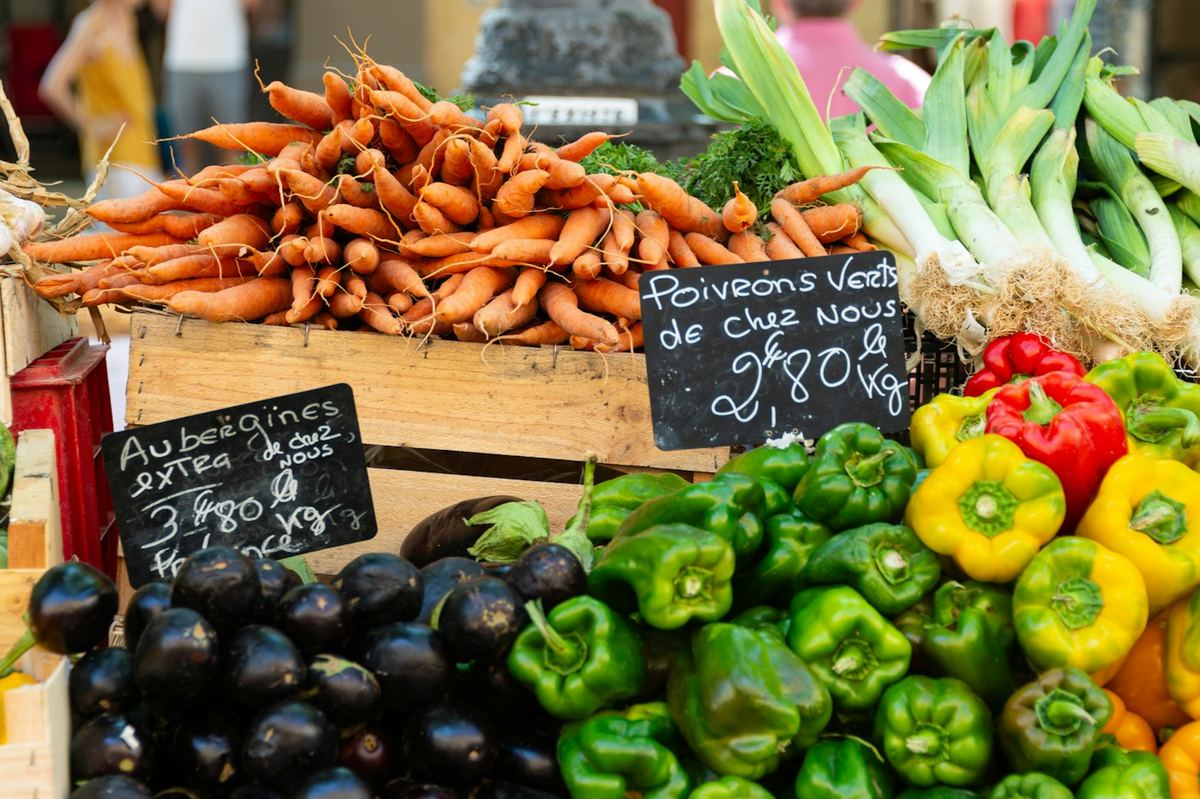 Étal de légumes sur un marché provençal, prix écrits à la craie