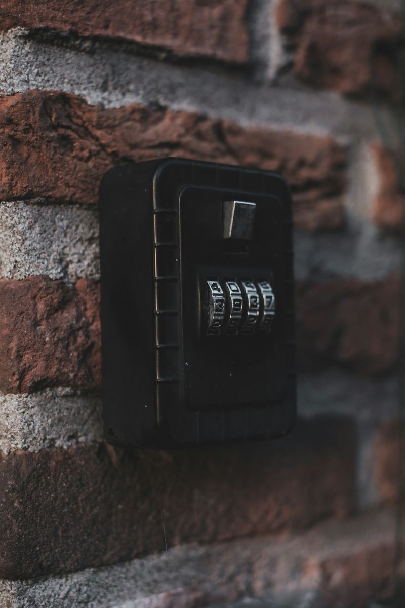 Boîte à clés à code fixée sur un mur de briques